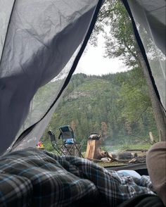 the view from inside a tent looking out at trees and mountains