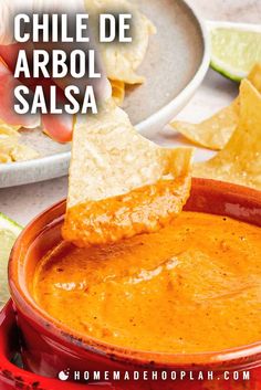 a red bowl filled with salsa and tortilla chips on top of the bowl