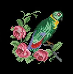 a cross stitch bird sitting on top of flowers