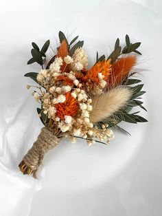 a bouquet of dried flowers on a white surface