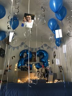 blue balloons and streamers are hanging from the ceiling