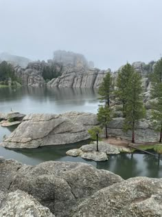 a lake surrounded by large rocks and trees