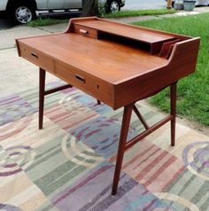 a wooden desk sitting on top of a rug