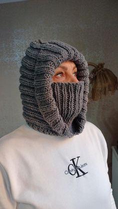 a man wearing a knitted hat and scarf with the hood pulled up over his face