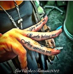 two people with tattoos on their hands and one has the words earth below them,