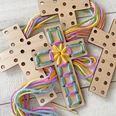 three wooden crosses with multicolored thread on them