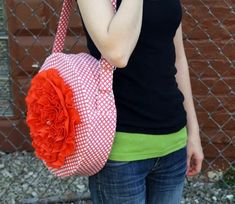 a woman is talking on her cell phone while holding a pink and white bag with red flowers