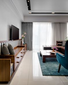 a living room filled with furniture and a flat screen tv mounted to the wall next to a window