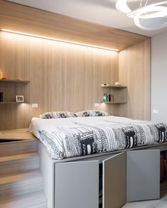 a bedroom with a bed, shelves and lights on the wall next to each other