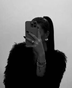 a woman taking a selfie with her cell phone in front of her earring