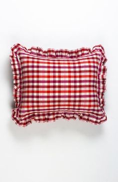 a red and white checkered pillow on a white background