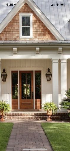 the front door of a house with two lights on each side and an entry way leading to it