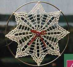 an ornament with a red ribbon is shown in the shape of a star