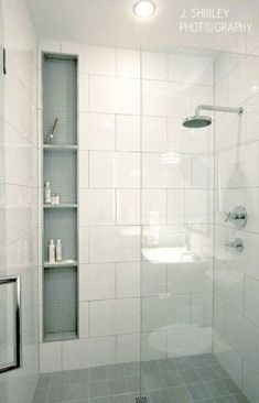 a bathroom with a shower, toilet and shelves on the wall next to each other