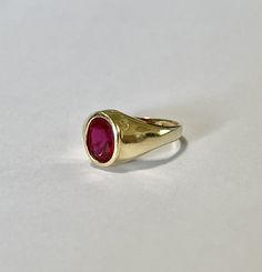 Amazing vintage 14k yellow gold created ruby ring, circa 1960s! The created red ruby weighs an estimated 1.21 carats, is oval cut, and is a stunning deep red. The setting contains a classic design with a high polish finish. Classic statement piece of fine retro jewelry showcasing a stunning created ruby, circa 1960s! ERA - Circa 1960s, Retro METAL / MATERIAL - 14k yellow gold, 1 created ruby (estimated 1.21 carats) [Synthetic ruby contains essentially the same chemical composition & properti Yellow Gold Ruby Signet Ring With Polished Finish, Heirloom Red Gold Signet Ring, Classic Gold Ruby Signet Ring, Vintage Ruby Rings With Polished Finish, Classic 14k Gold Red Signet Ring, Classic Red 14k Gold Signet Ring, Classic Red Signet Ring Stamped 14k, Vintage Ruby Signet Ring In Yellow Gold, Classic Ruby Signet Ring