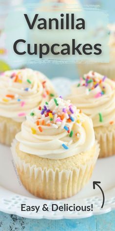 cupcakes with white frosting and sprinkles on a plate