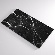 a black and white marbled piece of art sitting on top of a table next to a wall