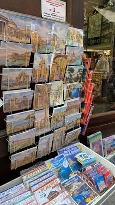 there are many magazines on display in the store front window, and one is for sale