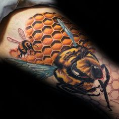 a man's arm with a bee and honeycomb tattoo on it