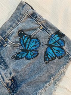 Hand-Painted Butterfly Shorts. UK size 8 (fits like a US size Small; cheeky). Upcycled vintage denim. London Jeans brand. Painted with acrylic paints mixed with a fabric medium and heat set. This item should be spot cleaned or dry cleaned. Short Pocket Painting, Jeans Painting Butterfly, Denim Short Painting Ideas, Fabric Painting Jeans, Fabric Paint Designs On Jeans, Denim Shorts Painting, Cute Fabric Painting, Painting Jean Shorts, Drawing On Shorts