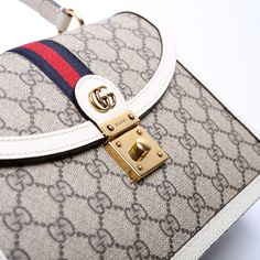 This Gucci Ophidia Small Top Handle Bag . The exterior is in the classic Gucci GG Supreme coated canvas. Condition: Very Good Serial Number: 651055 520981 Color: Tan and White Exterior: The exterior coated canvas is free from any rips or cracks. The corners show minor wear. Handle: The leather handles are free from any major signs of wear. Strap: The shoulder strapis free from wear. The strap has embossed initials. Hardware: The clasp closure has minor scratches. Interior: The interior features one zipper pocket and one open pocket. The interior is clean and free of any major signs of wear. Dimensions: L: 9.75" / H: 6.75" / D: 3.5" Handle Drop: 4" Strap Drop: 19" (Adjustable / Removable) Not Included: Original Dust BagFree delivery over $100 | Delivery 5-8 or 10-15 working days Please note High-end Coated Canvas Satchel With Detachable Strap, High-end Coated Canvas Crossbody Satchel, High-end Bag With Detachable Handle In Coated Canvas, Luxury Coated Canvas Shoulder Satchel, High-end Coated Canvas Bag With Detachable Handle, High-end Beige Monogram Canvas Bag, Luxury Bags With Detachable Strap In Coated Canvas, Luxury Bags With Adjustable Strap In Coated Canvas, Luxury Coated Canvas Bags With Detachable Strap