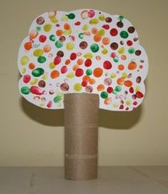 a toilet paper tree with lots of different colored dots on it's top and bottom