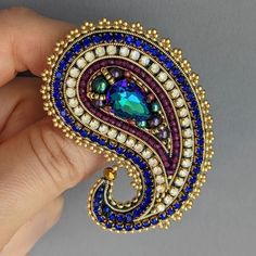 a person is holding a brooch in their hand