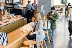 people are sitting at the counter in a restaurant and one person is on her cell phone