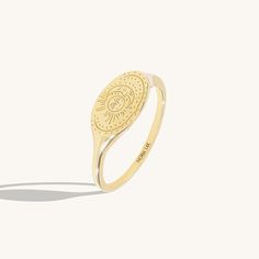 a gold ring with an oval design on it