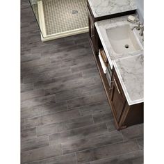 a bathroom with gray tile and wood flooring