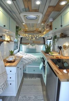 the interior of a camper with white walls and wood flooring is decorated in light blue