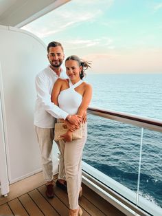 a man and woman standing on the deck of a cruise ship