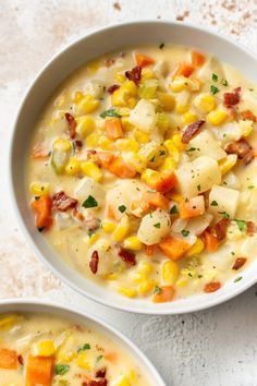 two bowls filled with corn and potato chowee on top of a white countertop