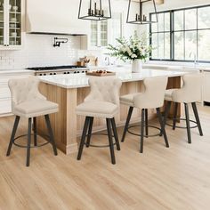 a kitchen island with four stools in front of it and an oven on the other side