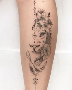 a woman's leg with a lion tattoo and flowers on her head, as well as an arrow