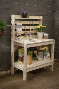 a potting bench made out of pallet wood with plants and gardening tools on top