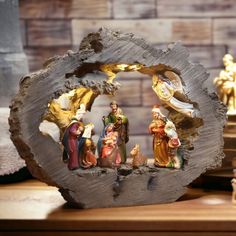 the nativity scene is displayed on top of a wooden stand with figurines