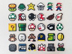 an array of pixelated video game icons on a white surface, including pacman, mario and more