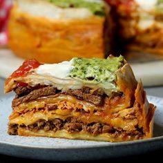 a close up of a slice of lasagna on a plate with another dish in the background