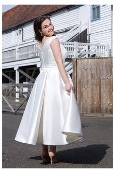 a woman in a white dress standing on the street