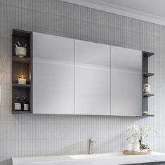 a bathroom with a sink, mirror and cabinets