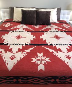 a bed with a red and white blanket on top of it