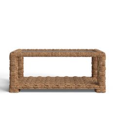 a wicker coffee table with a shelf on the top and bottom, against a white background