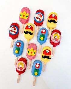 there are many lollipops on the stick with cartoon characters painted on them