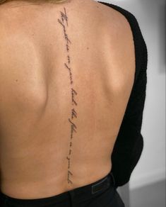 the back of a woman's neck with words written on it and in cursive writing