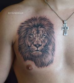 a man with a lion tattoo on his chest has a cross in front of him