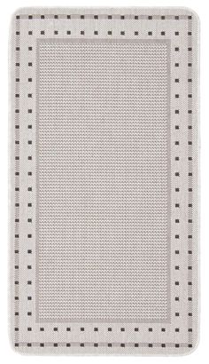 a square rug with black and white dots on the bottom, in front of a white background