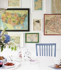 a dining room table with plates of food and pictures on the wall above it,