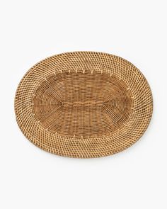 an oval rattan placemat on a white background