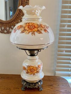 a white vase sitting on top of a wooden table